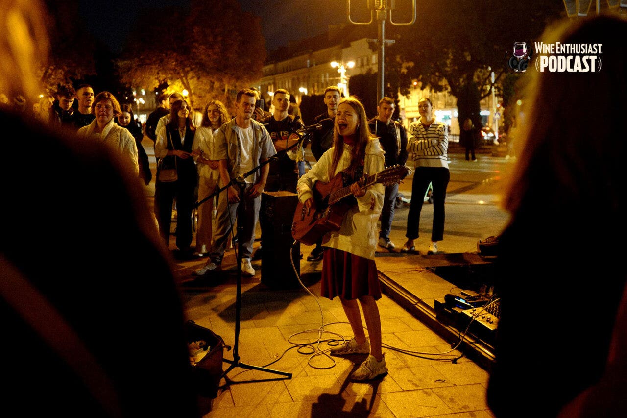 YOUNG PEOPLE CONGREGATE IN THE STREETS BEFORE CURFEW, SINGING AND DANCING TO RELEASE TENSION AND COLLECT MONEY FOR THE WAR EFFORT FOLLOWING THE ALL CLEAR FROM AN AIR SIREN. OCTOBER 2023.